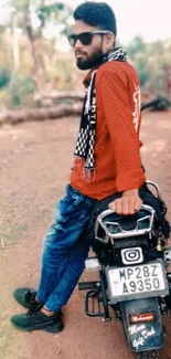 Person posing with motorcycle in nature.