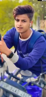 Young man on a blue motorcycle outside.