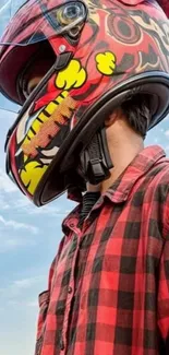 Person wearing a stylish motorcycle helmet and red plaid shirt under a blue sky.