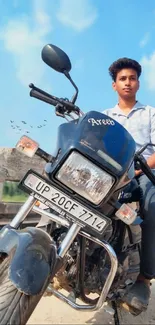 Young rider on motorcycle under blue sky.