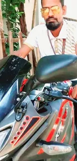 Man on black and red motorcycle in sunny outdoor setting.