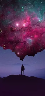 Silhouette beneath vibrant cosmic galaxy in mobile wallpaper.