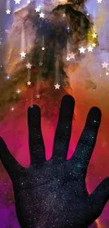 Silhouette hand reaching into cosmic galaxy with stars.