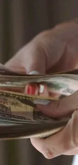 Close-up of hands counting U.S. dollar bills.