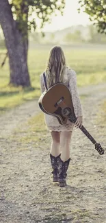 Woman walking along a country path holding a guitar.