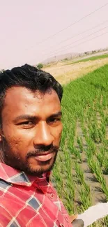 Farmer irrigating lush green fields in countryside setting.