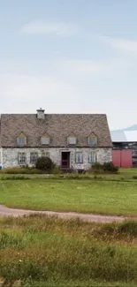 Charming stone house in Quebec countryside under a vast blue sky.