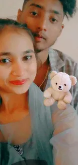 Smiling couple with teddy bear mobile wallpaper.