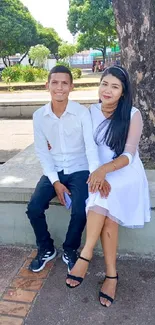 Couple sitting on a park bench under sunny trees.