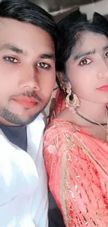 Elegant couple portrait with vibrant coral traditional attire.