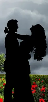 Silhouette of a couple in a vibrant flower field under a gray sky.