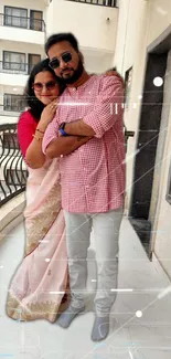 Couple in traditional attire on a balcony.