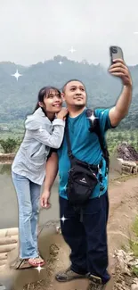 Couple taking a selfie in scenic countryside setting.