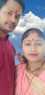 Couple with serene blue sky background and clouds.