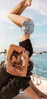 Couple performing yoga on a boat with ocean view.