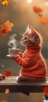 Kitten in an orange sweater sipping tea with autumn leaves floating.