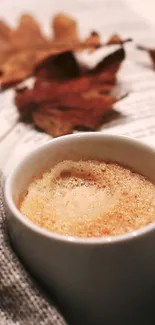 Cozy autumn scene with coffee, book, and leaves.