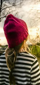 Girl in red beanie during autumn sunset.