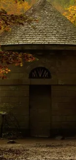 Stone cabin in autumn forest with vibrant foliage.