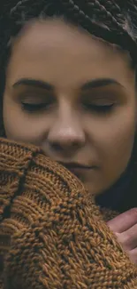 Woman in braided hairstyle with warm brown sweater.