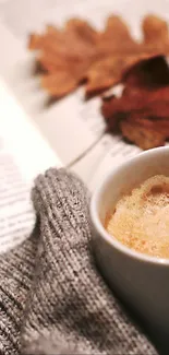 Cozy autumn wallpaper with coffee, book, and leaves.