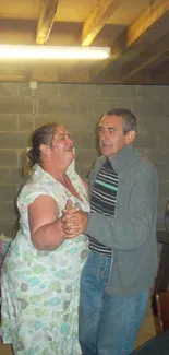 Two people dancing in a cozy basement setting.