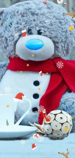 Teddy bear with red scarf and cup in a winter scene.