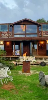 Cozy wooden cabin with fire pit and hammock in lush green setting.