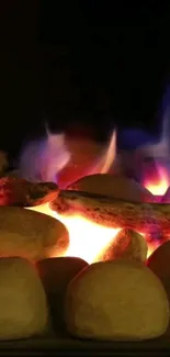 Cozy campfire with glowing stones and vibrant flames as a phone wallpaper.