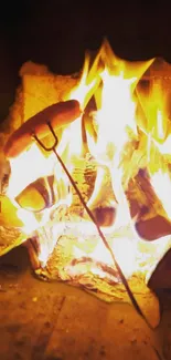 Roasting sausages over a vibrant campfire flame.