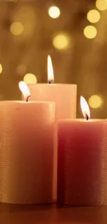 Three cozy candles glow softly with a warm bokeh background.