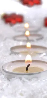 Candlelit winter scene with snow and red decor elements.