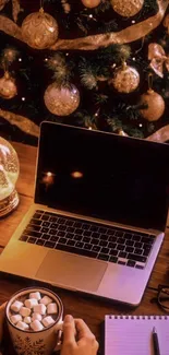 Cozy Christmas desk setup with laptop and festive decor.