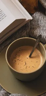 Cozy scene with coffee and book on a warm blanket.