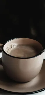 A cozy brown coffee cup on a saucer with a dark background.