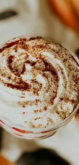 Cup of coffee with whipped cream and cinnamon topping.