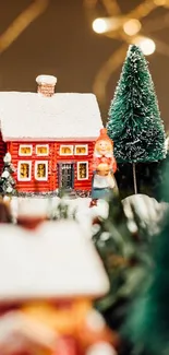 Red house in festive village setting with trees and lights.