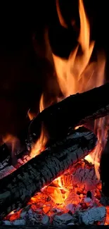 A close-up of a burning fireplace with vibrant orange flames and glowing embers.