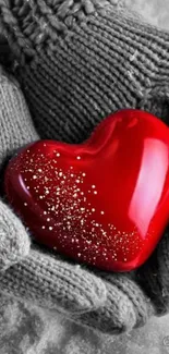 Hands in cozy gloves holding a red heart in winter scene.