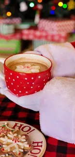 Santa holding a festive mug with hot chocolate and cookies.