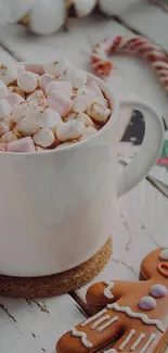 Cup of hot cocoa with marshmallows and gingerbread cookie on a wooden table.