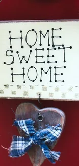 Home Sweet Home sign with red background and heart accents.