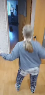 Girl dancing on a wooden floor indoors.