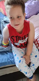 Child sitting on bed in colorful room decor.