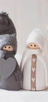 Cozy knitted figurines with hearts in gray and white tones.