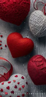 Wallpaper with cozy knitted hearts in red and gray fabrics.