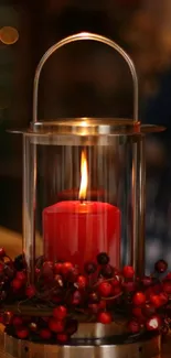 Rustic lantern with a glowing red candle and berry decorations.