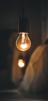 Mobile wallpaper of a glowing light bulb with a warm ambient setting.