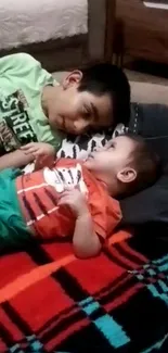 Two young siblings lie together, sharing a loving moment.