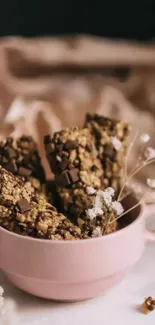 Chocolate oat bars in a pink cup with a beige background.